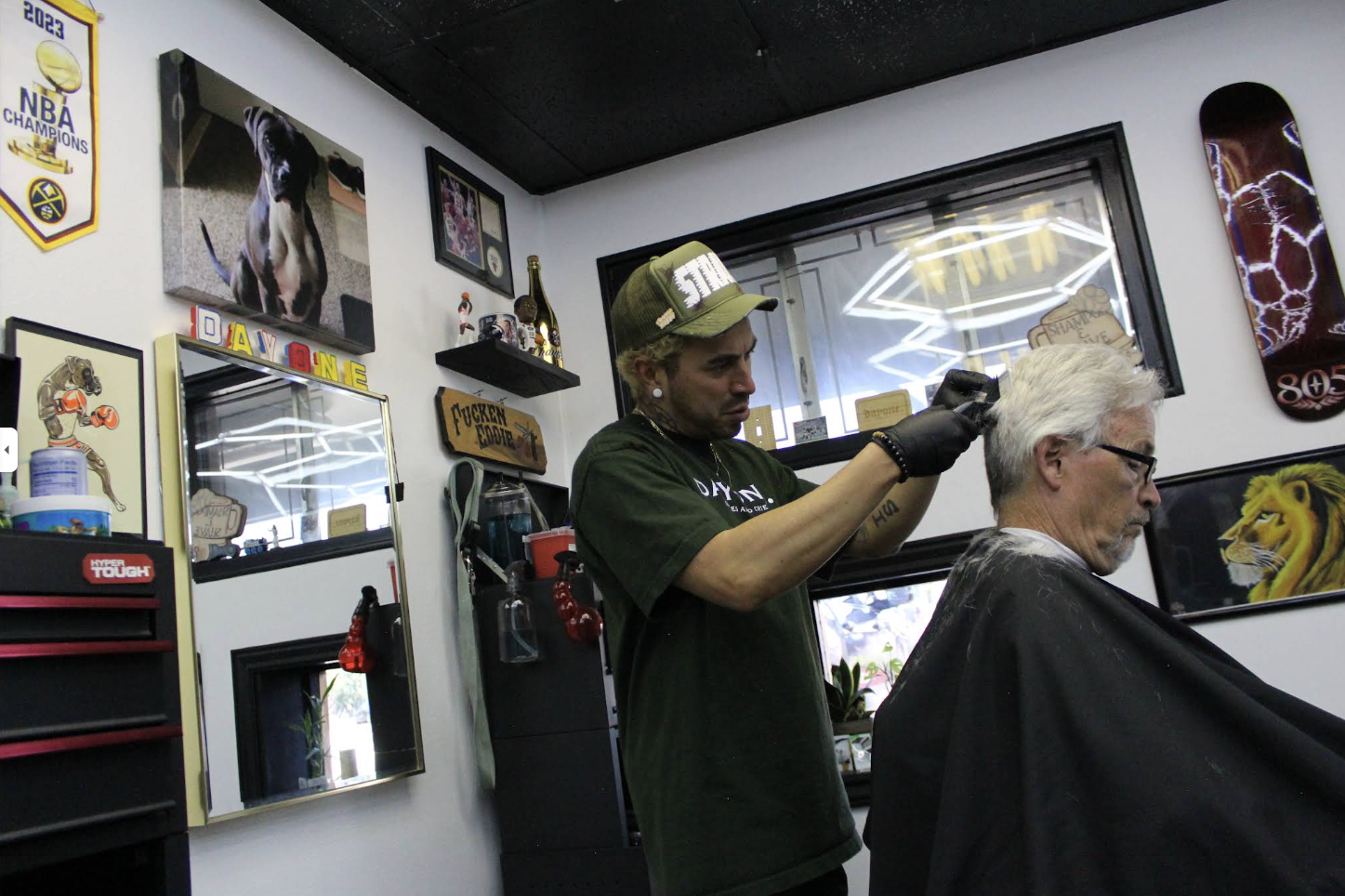 Eddie cutting hair inside Strays Barbershop