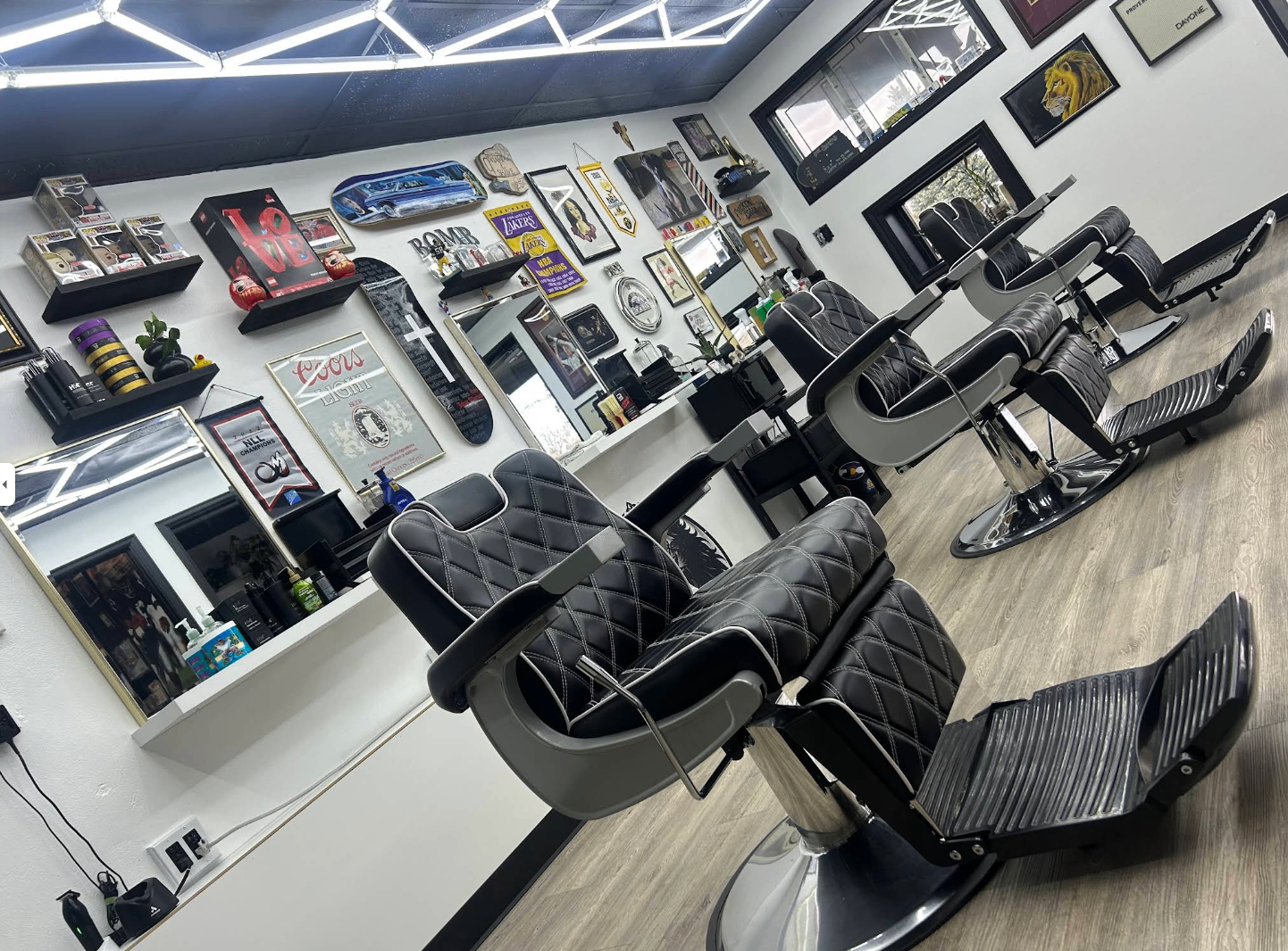 Strays Barbershop interior with black chairs and skateboard art on the walls